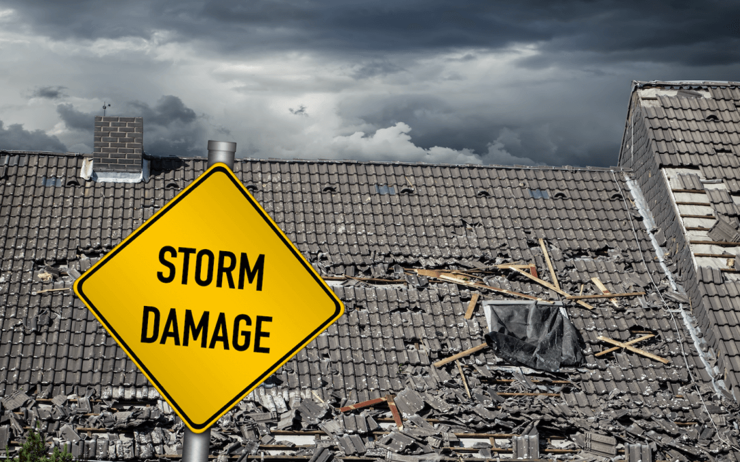 Photo of yellow storm damage sign with damaged roof in the background