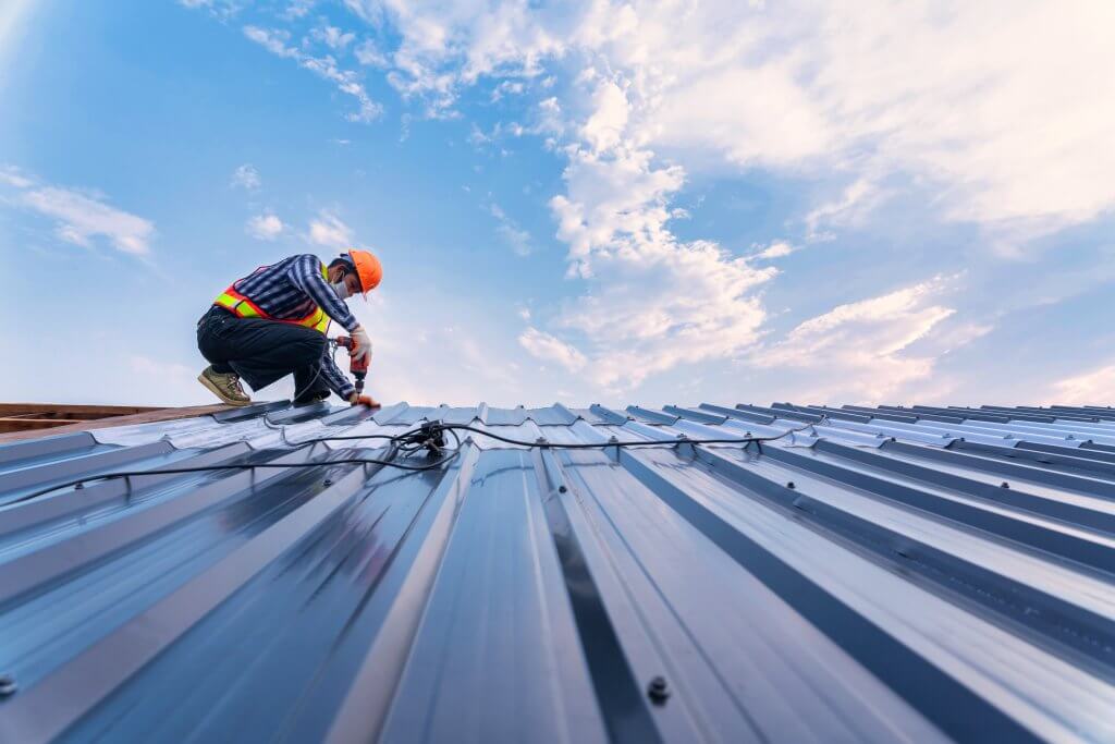 Roofing professional installing a new metal roof