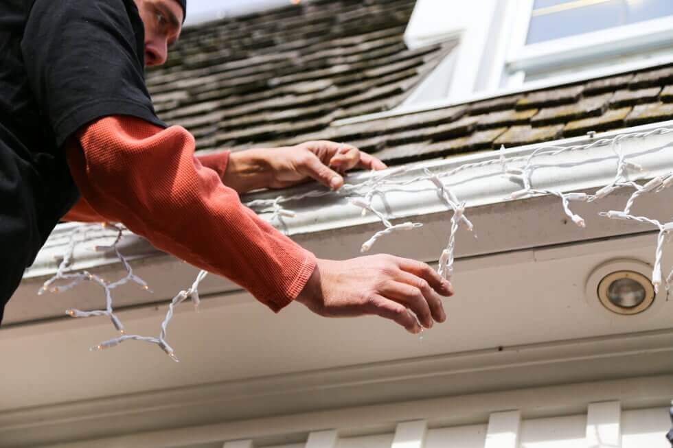 closeup of individual hanging christmas lights on their house