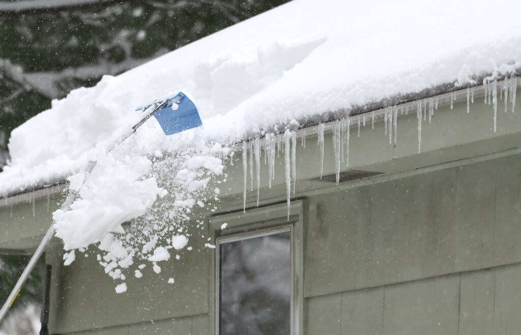 removing snow on the roof after snow storm