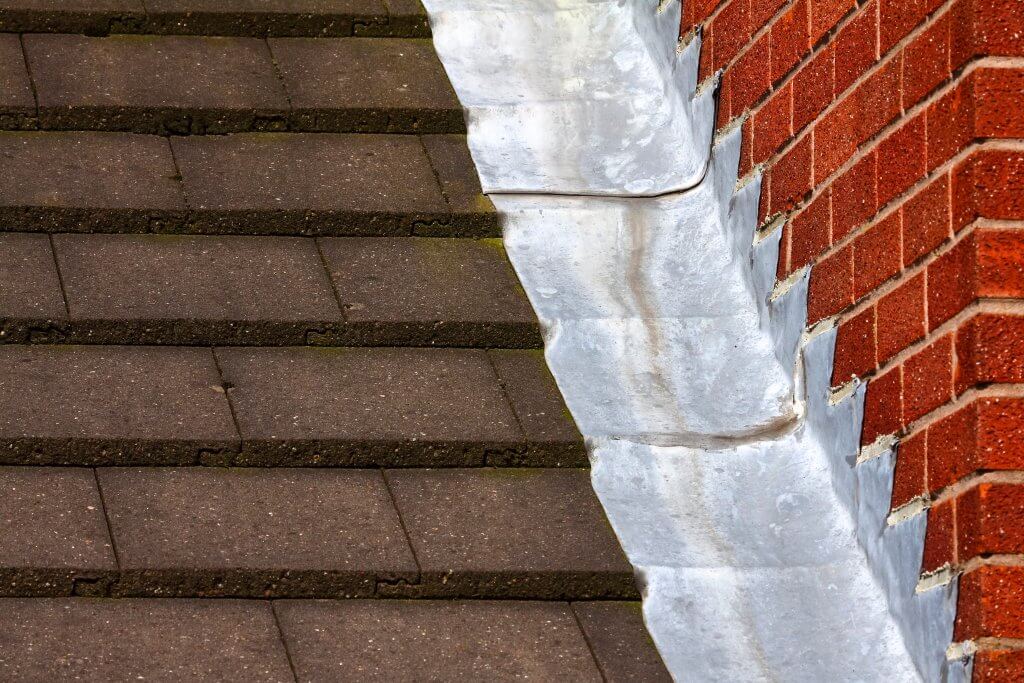 Stepped lead flashing roof gulley creating a water tight seal be